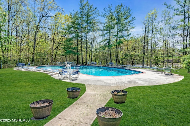 pool featuring a lawn, fence, and a patio area