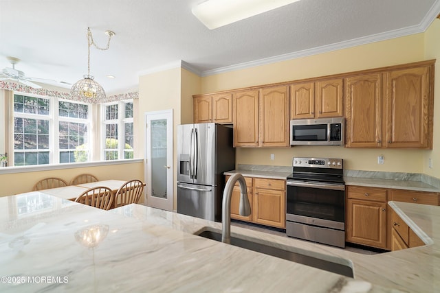 kitchen with ceiling fan, stainless steel appliances, crown molding, and hanging light fixtures