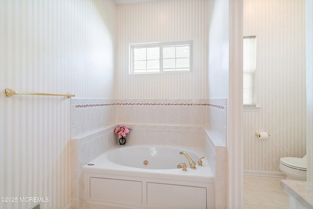 bathroom with a whirlpool tub, toilet, and wallpapered walls