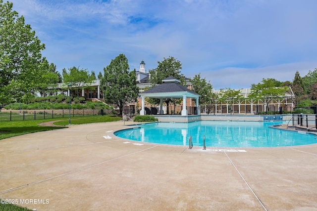 community pool with a gazebo, a patio area, and fence