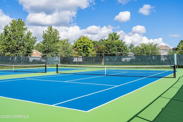view of tennis court featuring fence and community basketball court