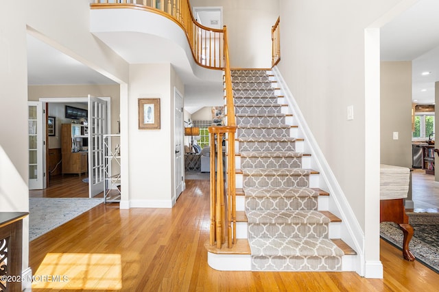 staircase featuring baseboards and wood finished floors
