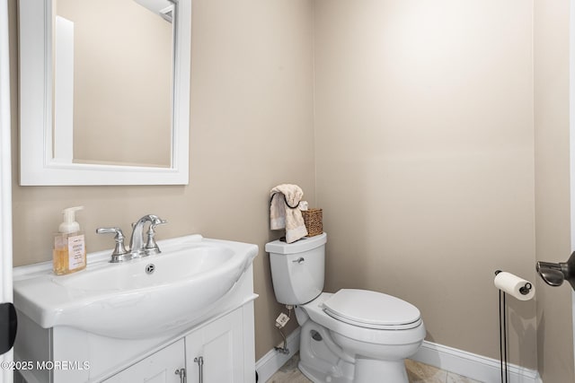 half bath with baseboards, toilet, and vanity