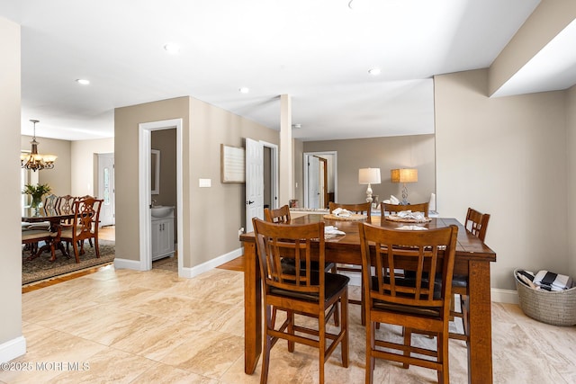 dining area featuring recessed lighting, baseboards, and a notable chandelier