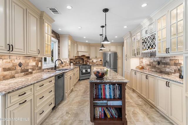 kitchen with a sink, cream cabinets, stainless steel appliances, and tasteful backsplash
