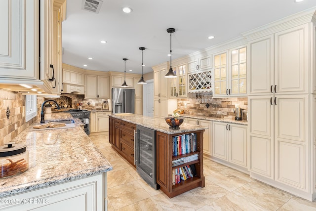 kitchen featuring visible vents, decorative backsplash, beverage cooler, a sink, and appliances with stainless steel finishes