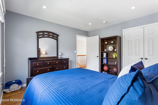 bedroom featuring recessed lighting, wood finished floors, and a closet