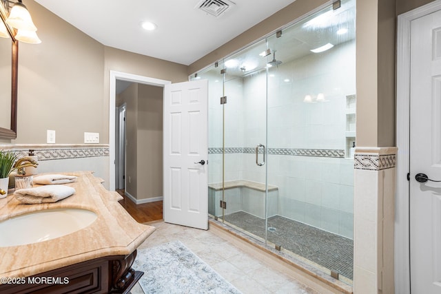 bathroom with a sink, double vanity, recessed lighting, a shower stall, and visible vents