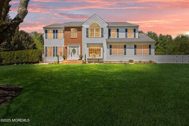 view of front of property with a lawn and a fenced backyard