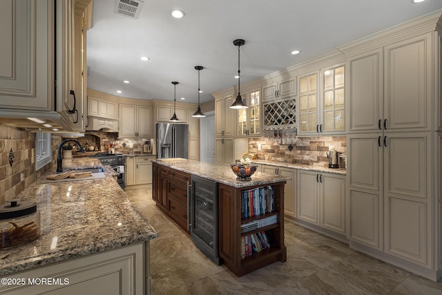 bar with appliances with stainless steel finishes, a sink, beverage cooler, decorative backsplash, and visible vents