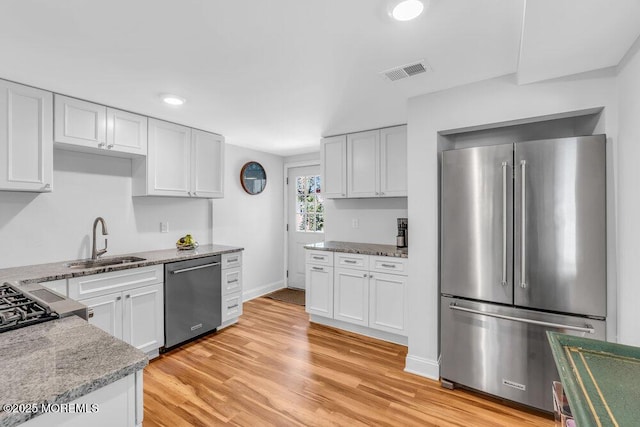4 W Lake Rd, Red Bank, NJ 07701 - kitchen with stainless steel appliances, a sink, light stone counters, white cabinets, and light wood-style flooring