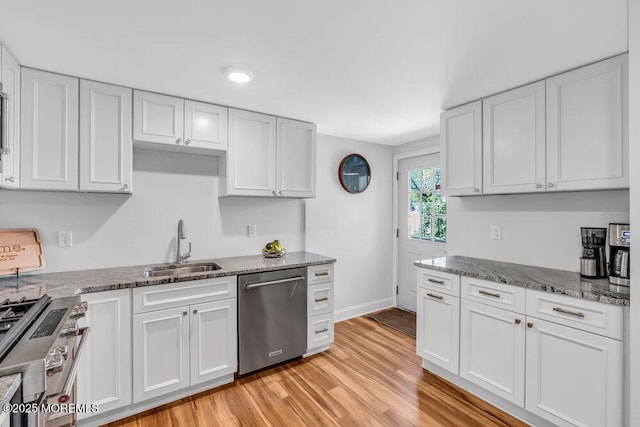 4 W Lake Rd, Red Bank, NJ 07701 - kitchen featuring appliances with stainless steel finishes, a sink, white cabinets, light wood finished floors, and stone countertops