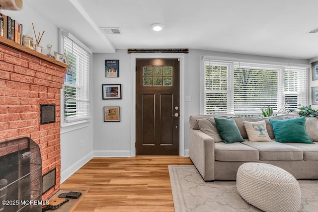 4 W Lake Rd, Red Bank, NJ 07701 - entrance foyer featuring a brick fireplace, light wood-type flooring, healthy amount of natural light, and baseboards