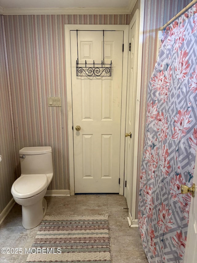 full bath featuring toilet, ornamental molding, wallpapered walls, and baseboards