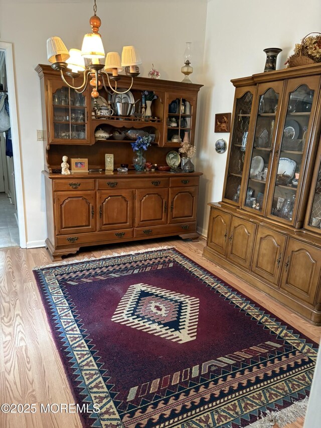 dining area with baseboards, a chandelier, and light wood-type flooring