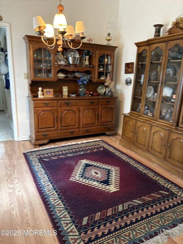dining area featuring an inviting chandelier, light wood finished floors, and baseboards