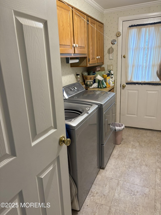 washroom with crown molding, cabinet space, and washing machine and dryer