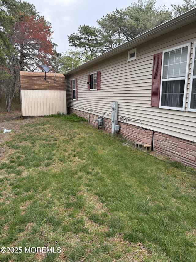 view of property exterior featuring an outdoor structure, a shed, a yard, and crawl space