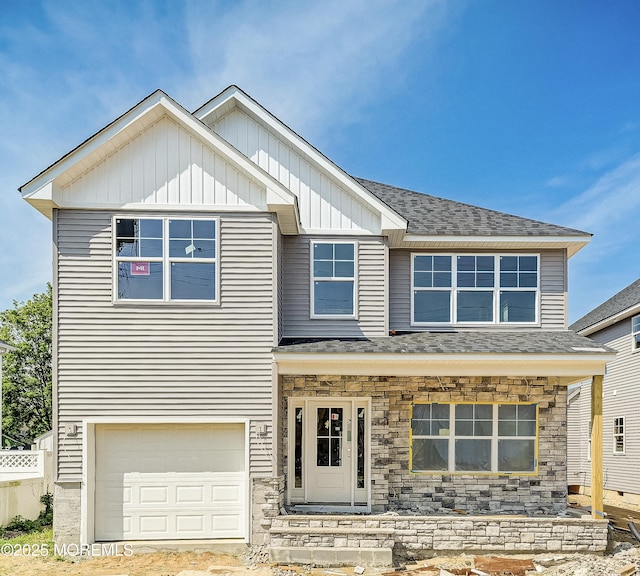 74 Manchester Ave, Keyport, NJ 07735 - view of front of house with board and batten siding, an attached garage, stone siding, and a shingled roof