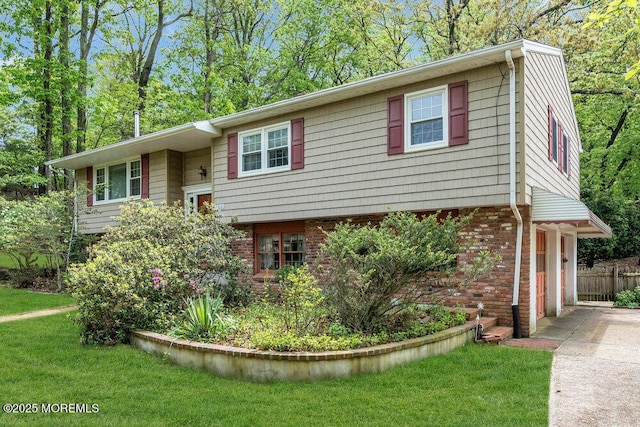 bi-level home featuring brick siding and concrete driveway