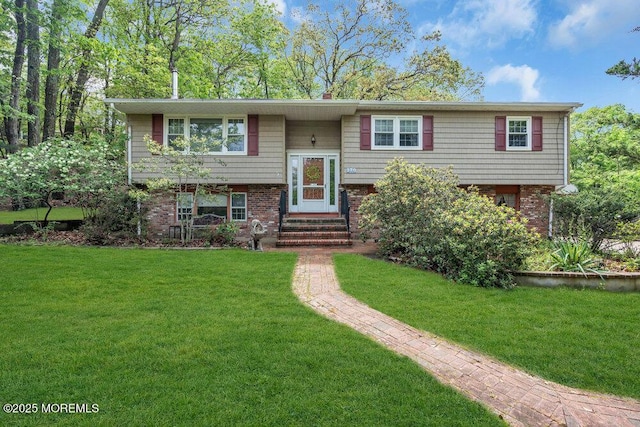 split foyer home featuring a front yard, brick siding, and entry steps