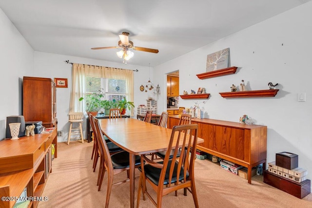 dining space with light colored carpet and ceiling fan