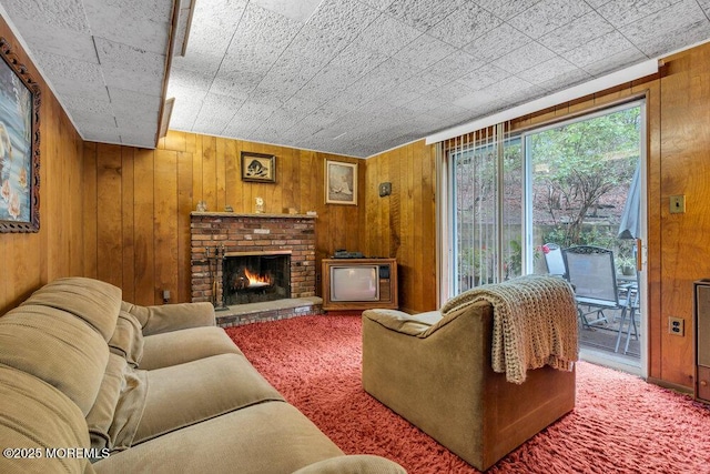 carpeted living area with wooden walls and a fireplace