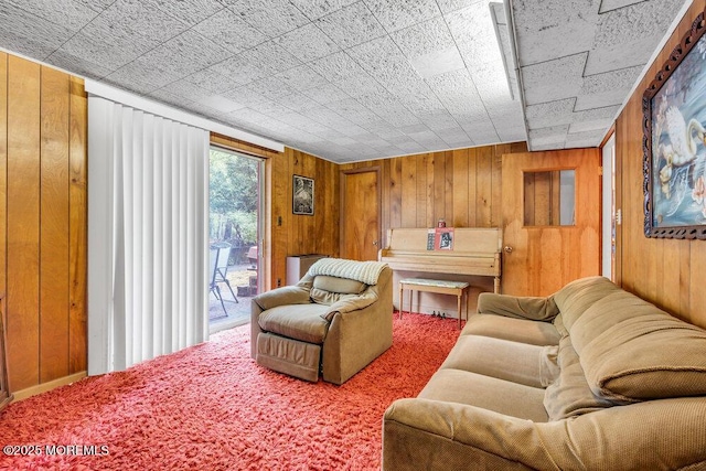 carpeted living area featuring wood walls