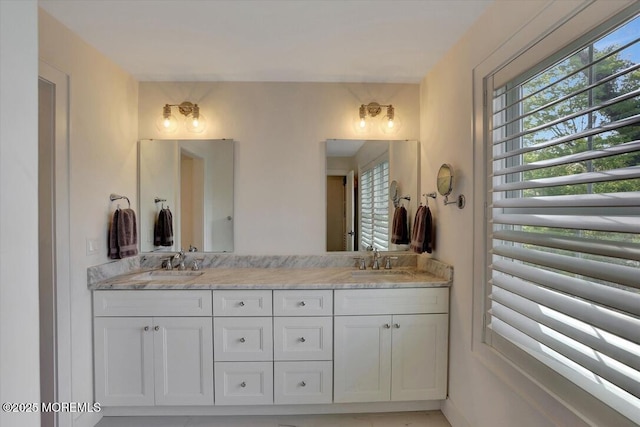 full bathroom featuring double vanity, a sink, and a wealth of natural light