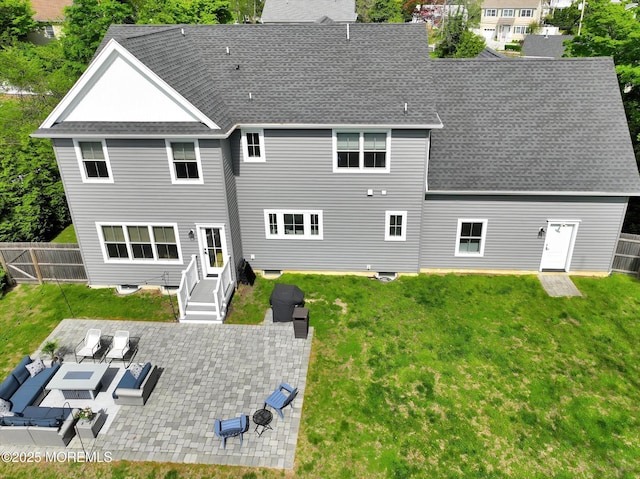 rear view of house featuring a patio, roof with shingles, fence, and a lawn