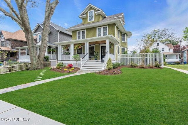 american foursquare style home with fence, a porch, and a front yard