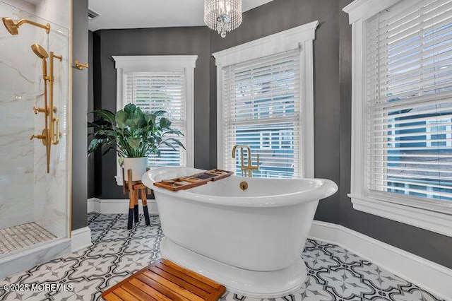 full bath with a freestanding tub, a marble finish shower, and a wealth of natural light