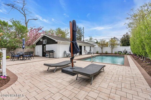 view of pool with grilling area, outdoor dining area, a fenced in pool, a fenced backyard, and a patio