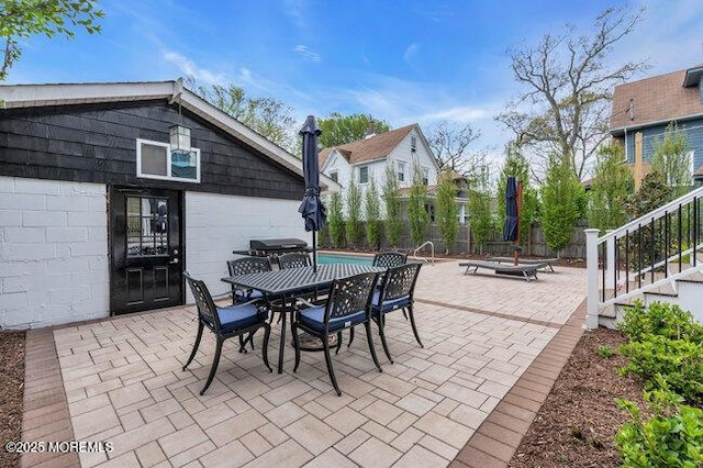 view of patio featuring fence, outdoor dining space, and an outdoor fire pit