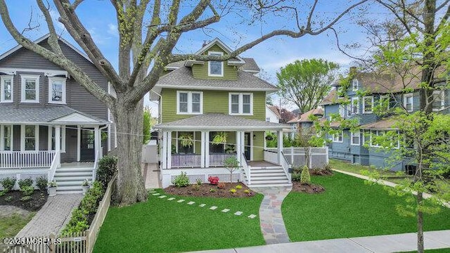 view of front facade with stairs, a porch, and a front yard
