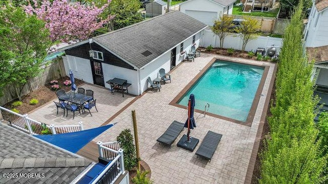 exterior space with a fenced in pool, a fenced backyard, outdoor dining space, and a patio area
