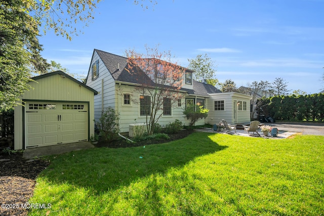 view of front facade featuring roof with shingles, an outdoor structure, a front yard, and a garage