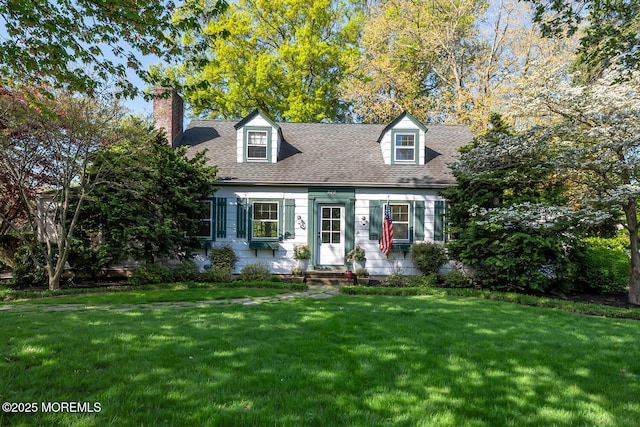 cape cod house with roof with shingles, a chimney, entry steps, and a front yard