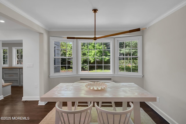 dining room with crown molding, baseboards, and dark wood finished floors