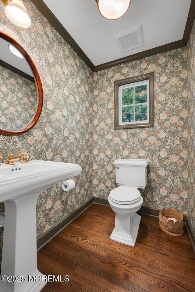 bathroom with toilet, baseboards, visible vents, and wood finished floors