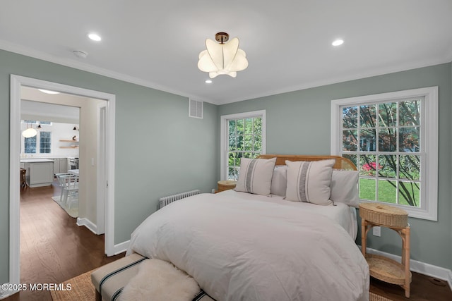 bedroom with radiator heating unit, baseboards, ornamental molding, and visible vents
