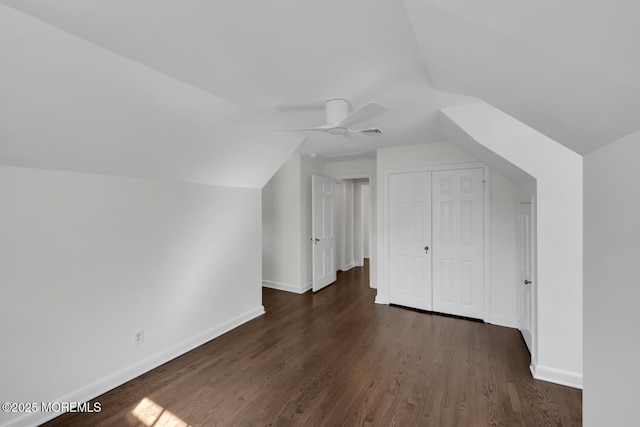 bonus room featuring a ceiling fan, dark wood-style flooring, visible vents, baseboards, and lofted ceiling