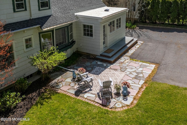 exterior space with a lawn and a shingled roof
