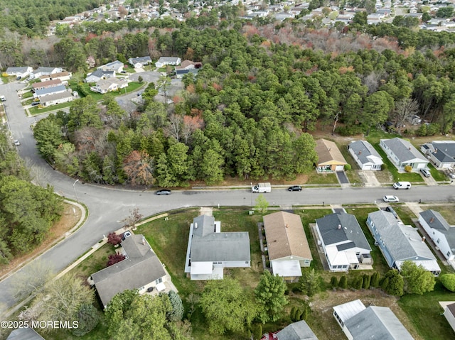 drone / aerial view with a wooded view and a residential view