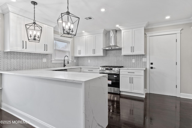 kitchen featuring wall chimney range hood, visible vents, gas range, white cabinets, and a notable chandelier