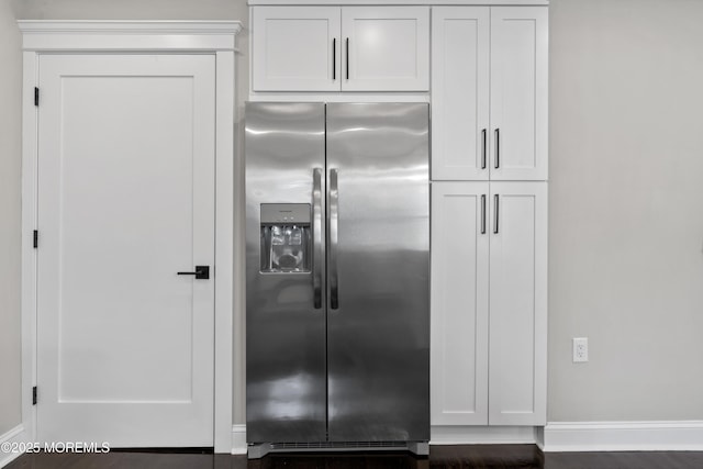 kitchen with white cabinets, baseboards, and stainless steel fridge