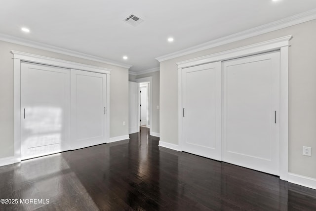 unfurnished bedroom with dark wood-style flooring, multiple closets, recessed lighting, and visible vents