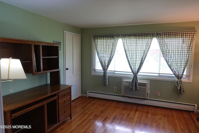 interior space featuring a wall mounted air conditioner, wood finished floors, baseboards, and a baseboard heating unit