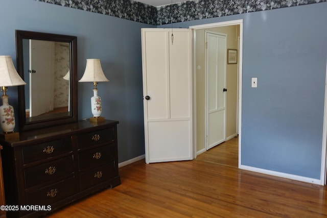 bedroom with wood finished floors and baseboards