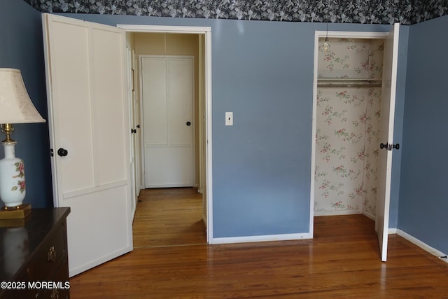 unfurnished bedroom with wood finished floors and baseboards